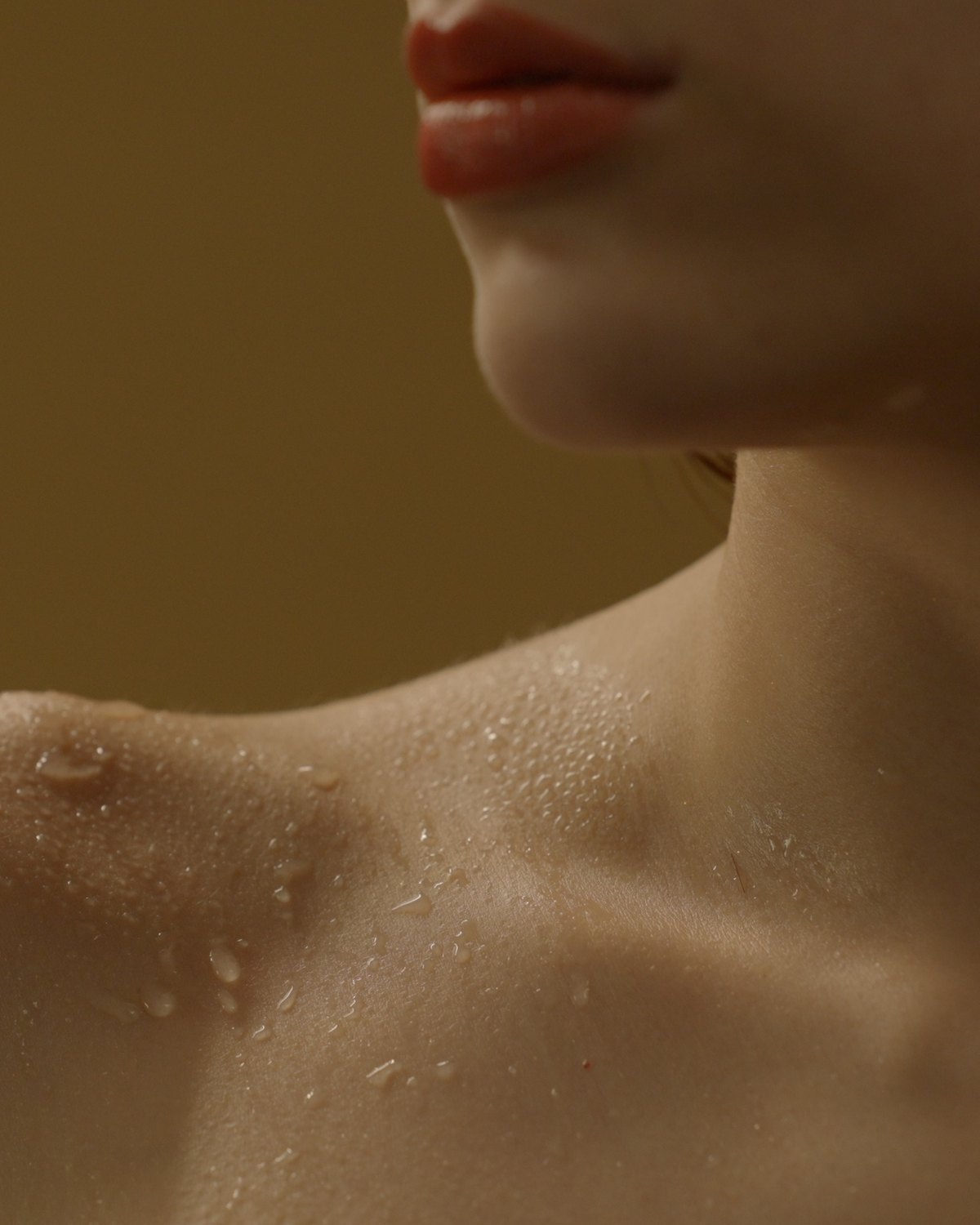 Neck and collarbone with water beading on the skin