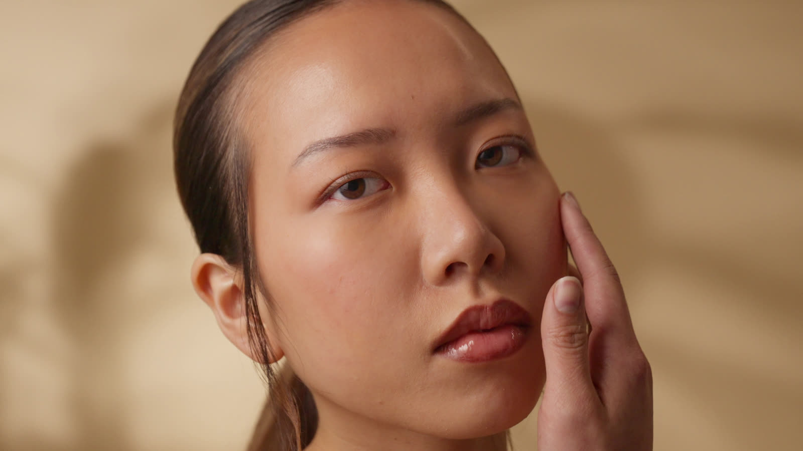 Fingertips resting on a cheek