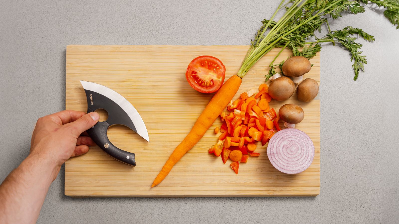 The board mid-prep: carrot, tomato, mushrooms and the blade