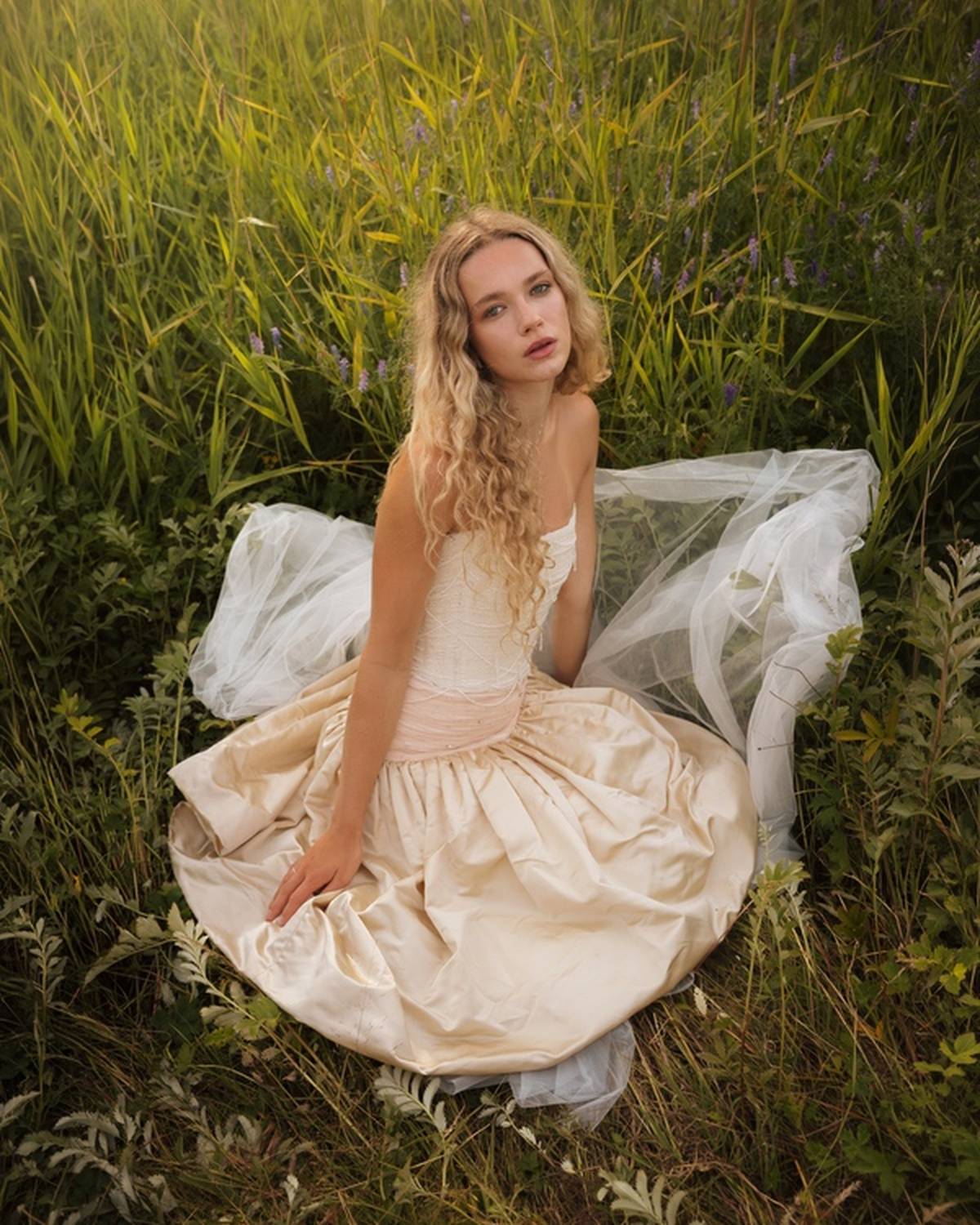 Seated in the meadow with the tulle spread across the grass