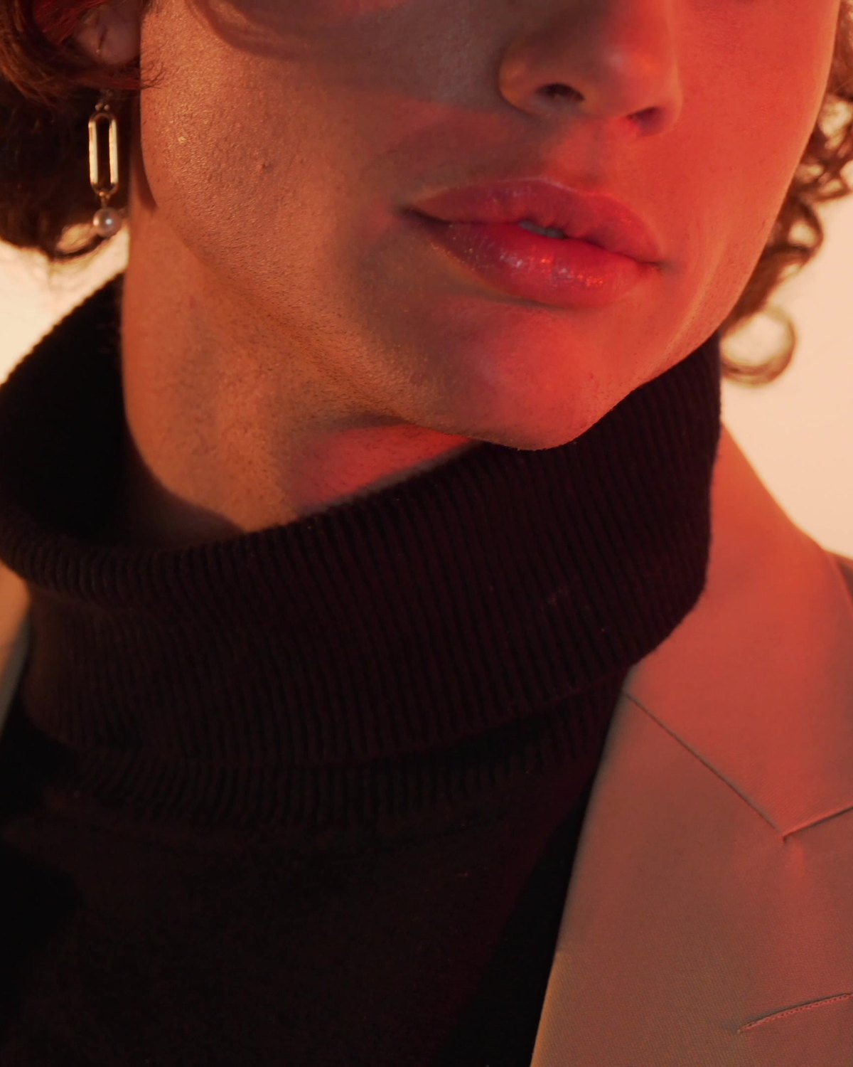 The jaw above the turtleneck, cropped close