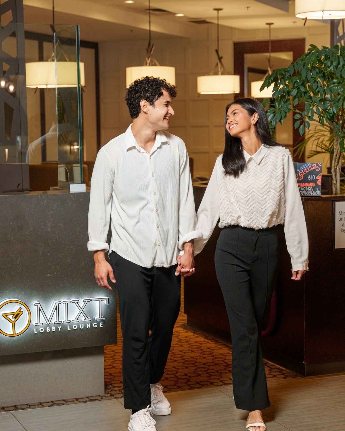A couple walking in through the branded entrance from the hotel lobby