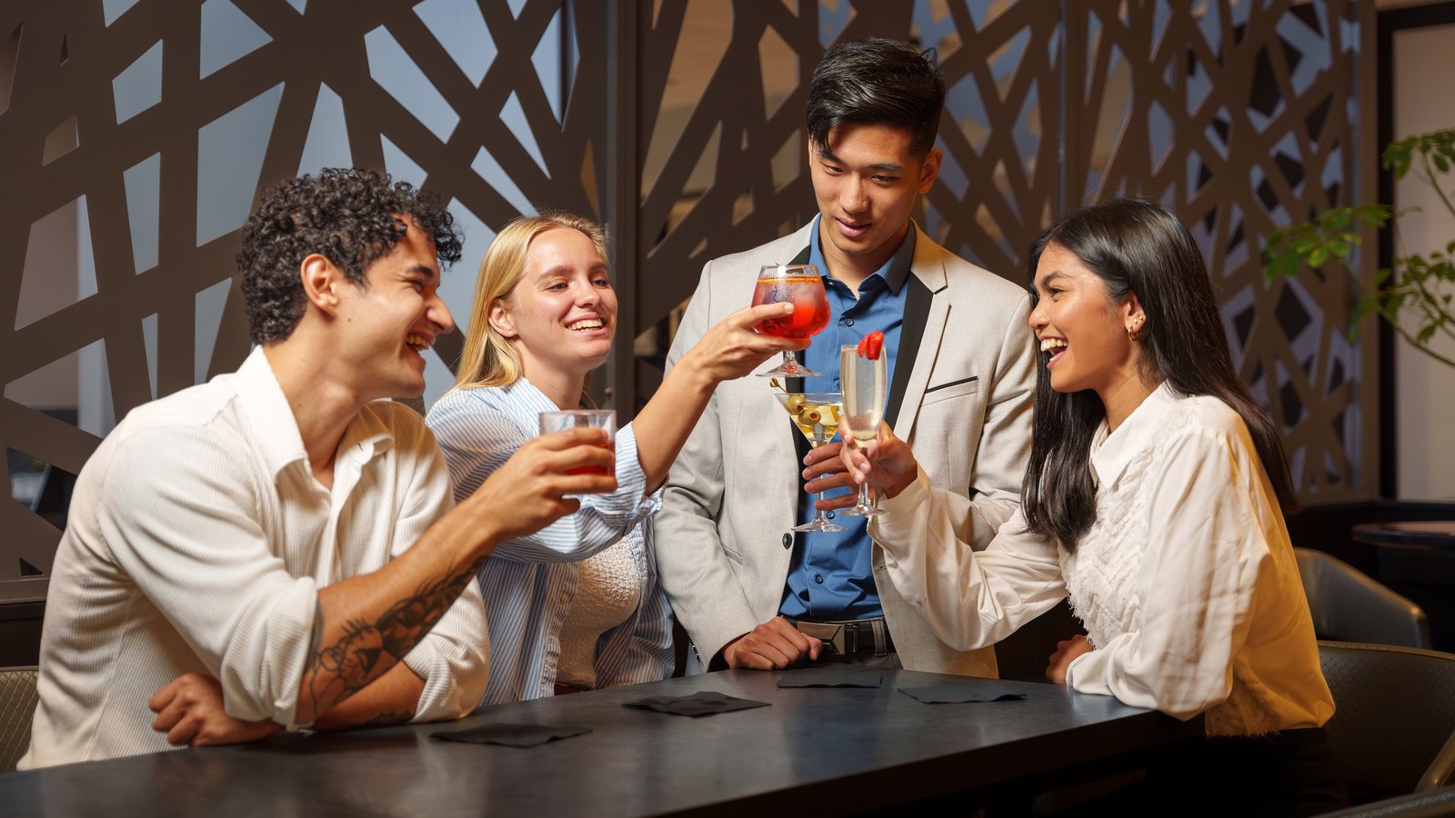 Four friends toasting at the high-top