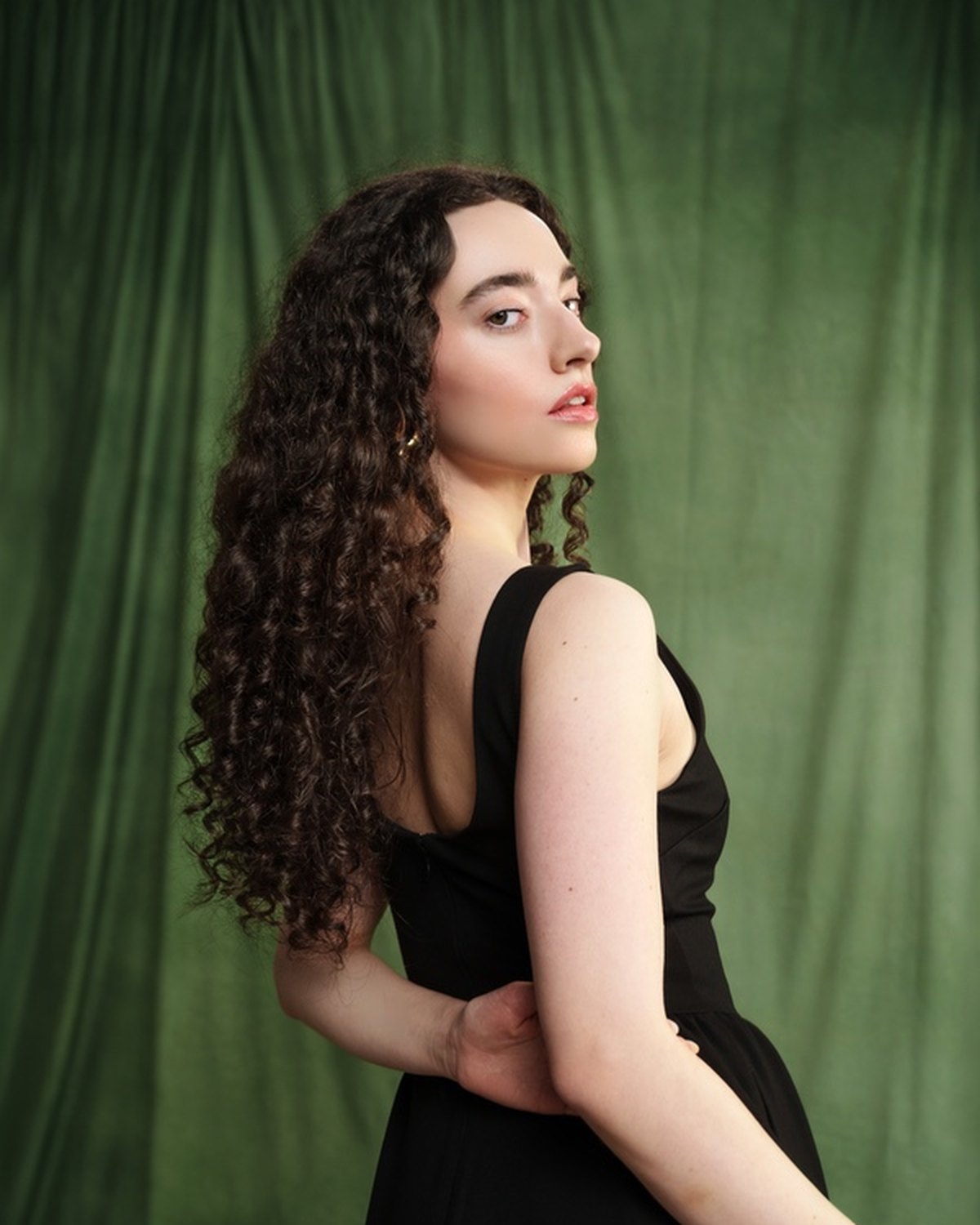 Look two: turned away, the bare shoulder against deep green